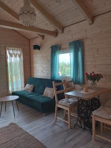 a living room with a green couch and a table at Domek Polna Cisza Bieszczady in Lesko