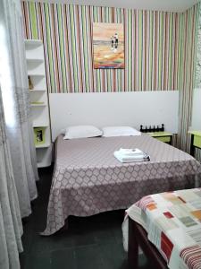 - une chambre avec un lit et un mur rayé dans l'établissement Suíte 06 Exclusiva e Independente, à Cuiabá