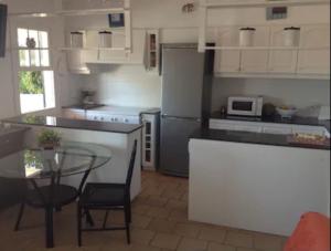 a kitchen with a counter and a table and a refrigerator at Wonderful Apartment on the Beach in Son Parc