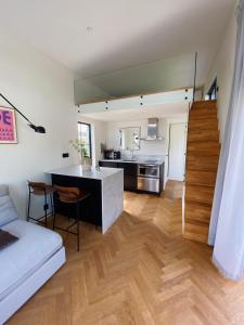 a kitchen and a living room with a counter and a table at Guesthouse, not even a minute walk to the ocean in Kullavik