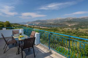 阿爾戈斯托利的住宿－Bleu clair luxury living，设有一个配有桌椅并享有美景的阳台。