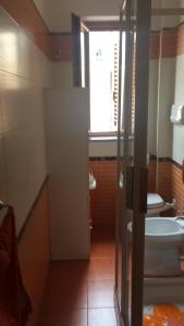 a bathroom with a toilet and a sink and a window at Casa Marco in Praia a Mare +10 photos