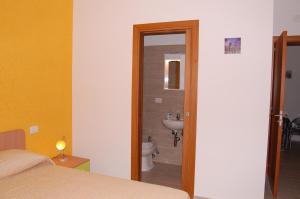 a bedroom with a bathroom with a toilet and a sink at B&B Fenix in Trani