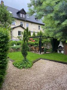 un jardín con un pequeño árbol y una casa en Apartamenty Sudeckie nad zalewem, en Sosnówka