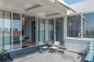 a patio with glass windows and a table and chairs at Penthouse Apartment in Zadar