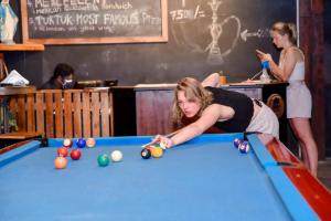 a woman playing pool in a pool table at Tuk Tuk Boutique Hotel in Negombo