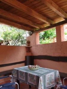 a table with a table cloth on a patio at Villetta Kala E Moru Sa oghe e su mare in Geremèas