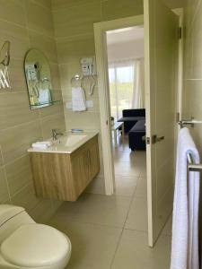 uma casa de banho com um WC, um lavatório e um espelho. em Vista Golf Playa Nueva Romana em La Romana