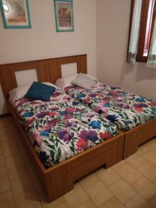 a bed with a comforter on it in a bedroom at Villetta Kala E Moru Sa oghe e su mare in Geremèas