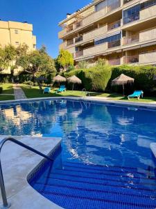 a large swimming pool in front of a building at Comfy apartment in the heart of the Costa del Sol in Mijas Costa