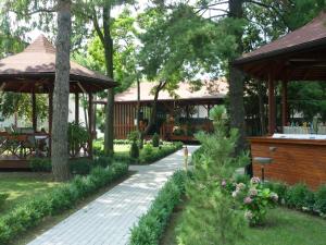 a walkway in a garden with a pavilion and trees at Hotel Baneasa Parc in Bucharest