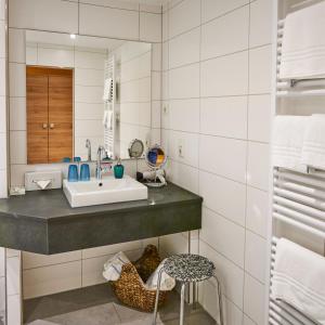 La salle de bains est pourvue d'un lavabo et d'un miroir. dans l'établissement Land-gut-Hotel Forellenhof, à Bundenbach