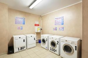 a laundry room with three washer and dryers at Résidence Nemea Roubaix Eurotéléport in Roubaix