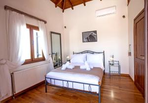 a bedroom with a bed with two teddy bears on it at Villa Greco in Platanias