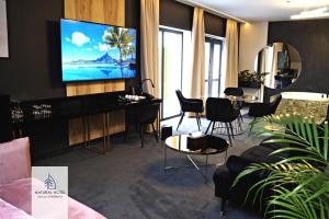 Televisyen dan/atau pusat hiburan di Natural Hotel w Rezerwacie z Plażą Na Wyspie
