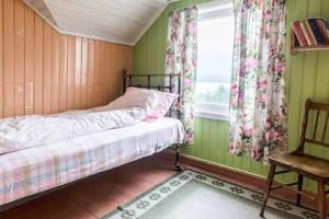 um quarto com paredes verdes, uma cama e uma janela em Mor's hus em Valle