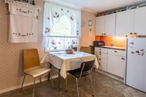 uma cozinha com uma mesa e cadeiras e um frigorífico em Mor's hus em Valle