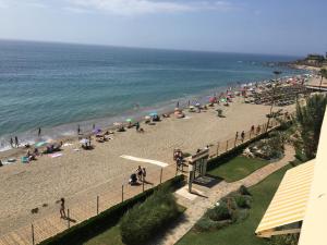 Un grupo de personas en una playa con el océano en Apartamento Las Mimosas Beach 2, en La Cala de Mijas