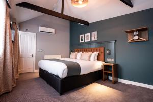 um quarto com uma cama grande e uma parede azul em The Mitre by Innkeeper's Collection em Londres