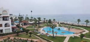 - une vue sur un complexe avec une piscine et l'océan dans l'établissement Marina beach, à Fnideq