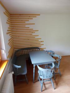 a table and chairs in a room with a wooden wall at Lahova hiša in Ljubno