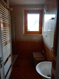 a small bathroom with a sink and a window at Lahova hiša in Ljubno