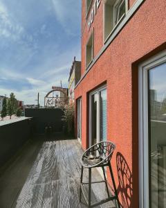 a chair sitting on a deck next to a building at North-Hotel in Hamburg