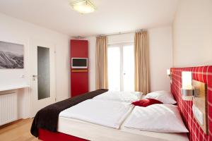 - une chambre avec un grand lit et un mur rouge dans l'établissement Alpenflair Ferienwohnungen Gästehaus Hilbrand Whg 313,314,215, à Oberstdorf