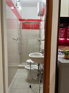 bagno con lavandino, doccia e servizi igienici di Monolocale Rosso - A casa di Ludovica e Martina a Gallipoli