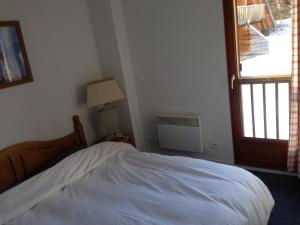 a bedroom with a white bed and a window at Le petit chalet Les Flocons du soleil in Le Dévoluy