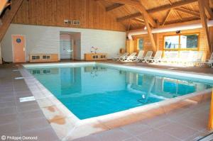 a large swimming pool in a large building at Petit Chalet 5 pers piscine sauna 2 chambres in Le Dévoluy