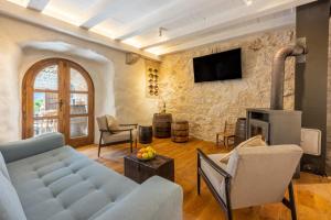 uma sala de estar com um sofá e uma parede de pedra em STARA KUĆA - old stone house em Grižane
