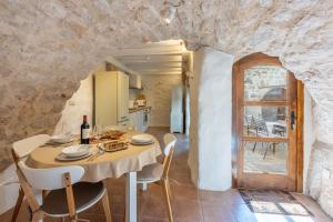 a kitchen and dining room with a table and chairs at STARA KUĆA - old stone house in Grižane