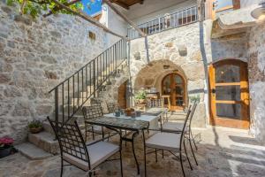 een patio met een tafel en stoelen in een stenen gebouw bij STARA KUĆA - old stone house in Grižane
