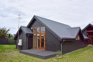 a black house with a black roof at Kotedžai GULBĖS TAKAS Šventojoje in Šventoji +73 photos