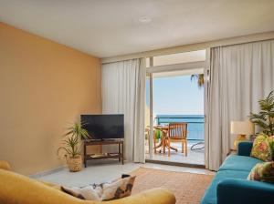 un soggiorno con divano e TV e un balcone di Lovely apartment with pool and sea view a Funchal