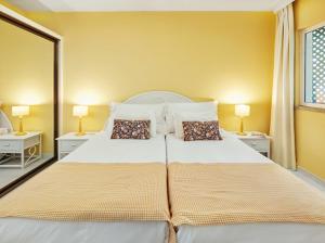 een slaapkamer met een groot wit bed met twee kussens bij Lovely apartment with pool and sea view in Funchal +9 foto's