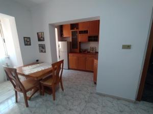 een keuken met een tafel en stoelen en een koelkast bij Mammy's Home in Tirana