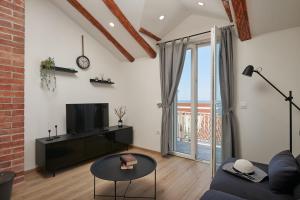 a living room with a couch and a tv at Apartments Maruna in Cavtat