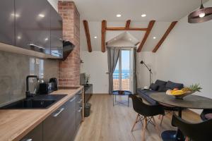 a kitchen and living room with a couch and a table at Apartments Maruna in Cavtat