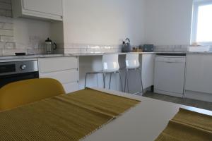 una cucina con banconi bianchi ed elettrodomestici bianchi di Seaside House Broadstairs by the Beach with Parking a Broadstairs