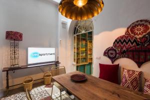 een woonkamer met een tafel en een televisie bij Veoapartment Casa Alfonso XII in Sevilla