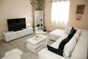 a living room with a white couch and a flat screen tv at Apartment Tina in Vodice