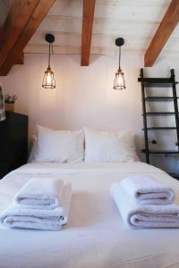 ein Schlafzimmer mit einem weißen Bett und Handtüchern darauf in der Unterkunft Qué bueno que viniste. Edificio singular in Plasencia