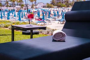 a table with a drink on it next to a beach at Pavlo Napa Beach Hotel in Ayia Napa