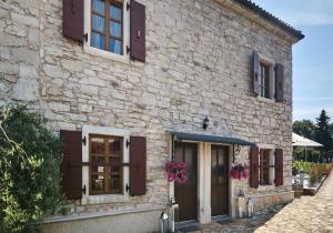 a stone house with purple windows and doors at San Niccolo 2 in Vilanija