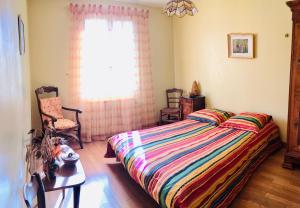 a bedroom with a bed with a colorful striped comforter at Le refuge des canards in Saint-Aubin-le-Cloud