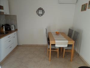 een keuken met een tafel en stoelen in een kamer bij Apartmani Mirko LJubač in Ražanac