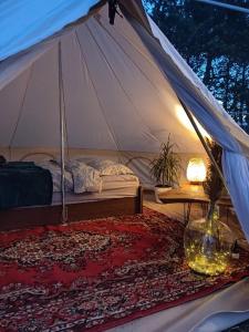 sypialnia z namiotem z łóżkiem i stołem w obiekcie Glempinga telts SMILGA w mieście Lipawa