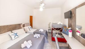 a room with two beds and a flat screen tv at Hotel Condor-New 2024-Con Piscina in Riccione